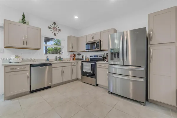 a kitchen with white cabinets and stainless steel appliances