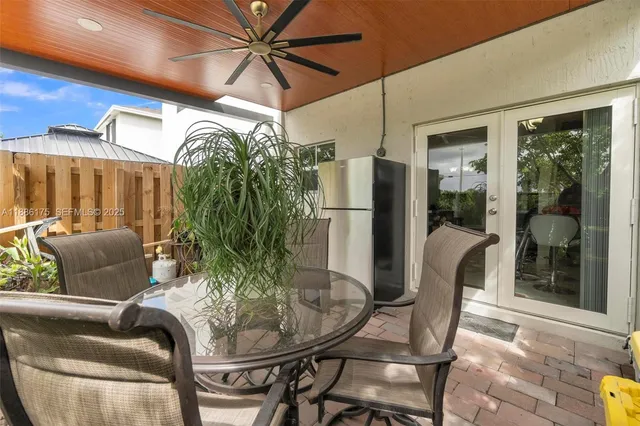 a view of a patio with table and chairs potted plants with wooden floor and fence