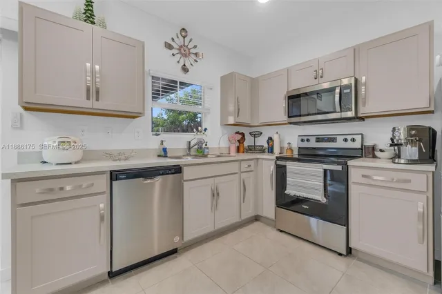 a kitchen with stainless steel appliances granite countertop white cabinets a sink and dishwasher