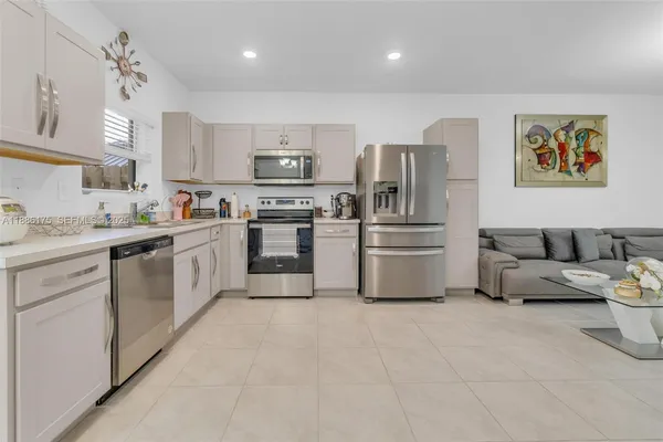 a kitchen with stainless steel appliances a refrigerator sink and cabinets