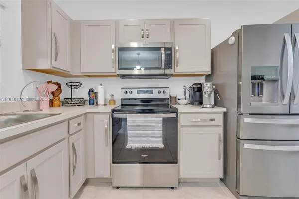 a kitchen with white cabinets and stainless steel appliances