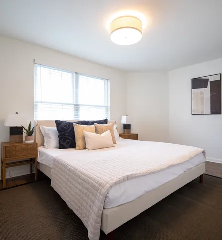 a bedroom with bed and a large window