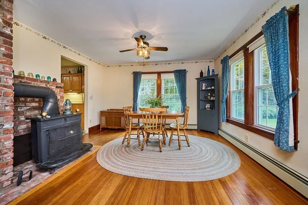 a dining room with wooden floor a chandelier a wooden table and chairs