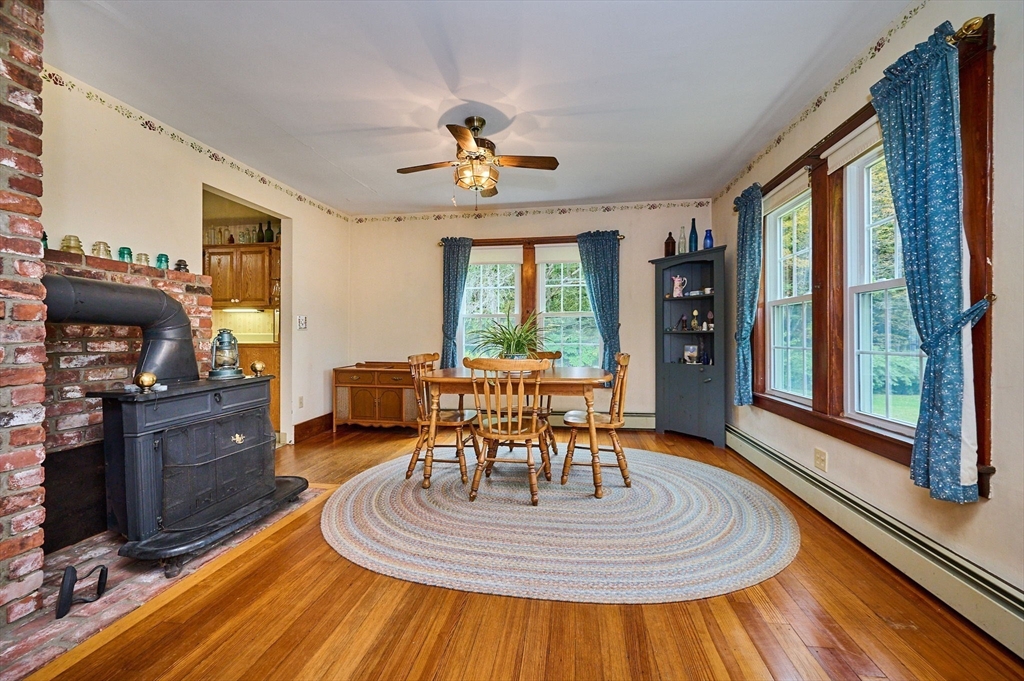 102 Elm Street Buckland, MA 01370 - Photo 12 of 35 a dining room with wooden floor a chandelier a wooden table and chairs