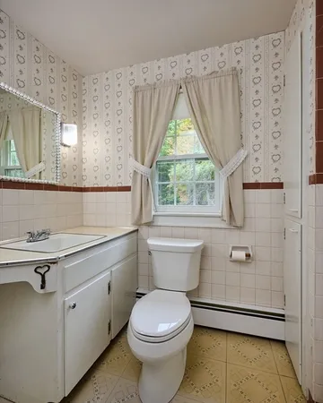 a bathroom with a toilet a sink and a window