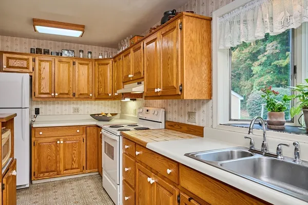 a kitchen with a sink a counter top space cabinets and a window
