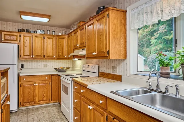 a kitchen with a sink a counter top space cabinets and a window