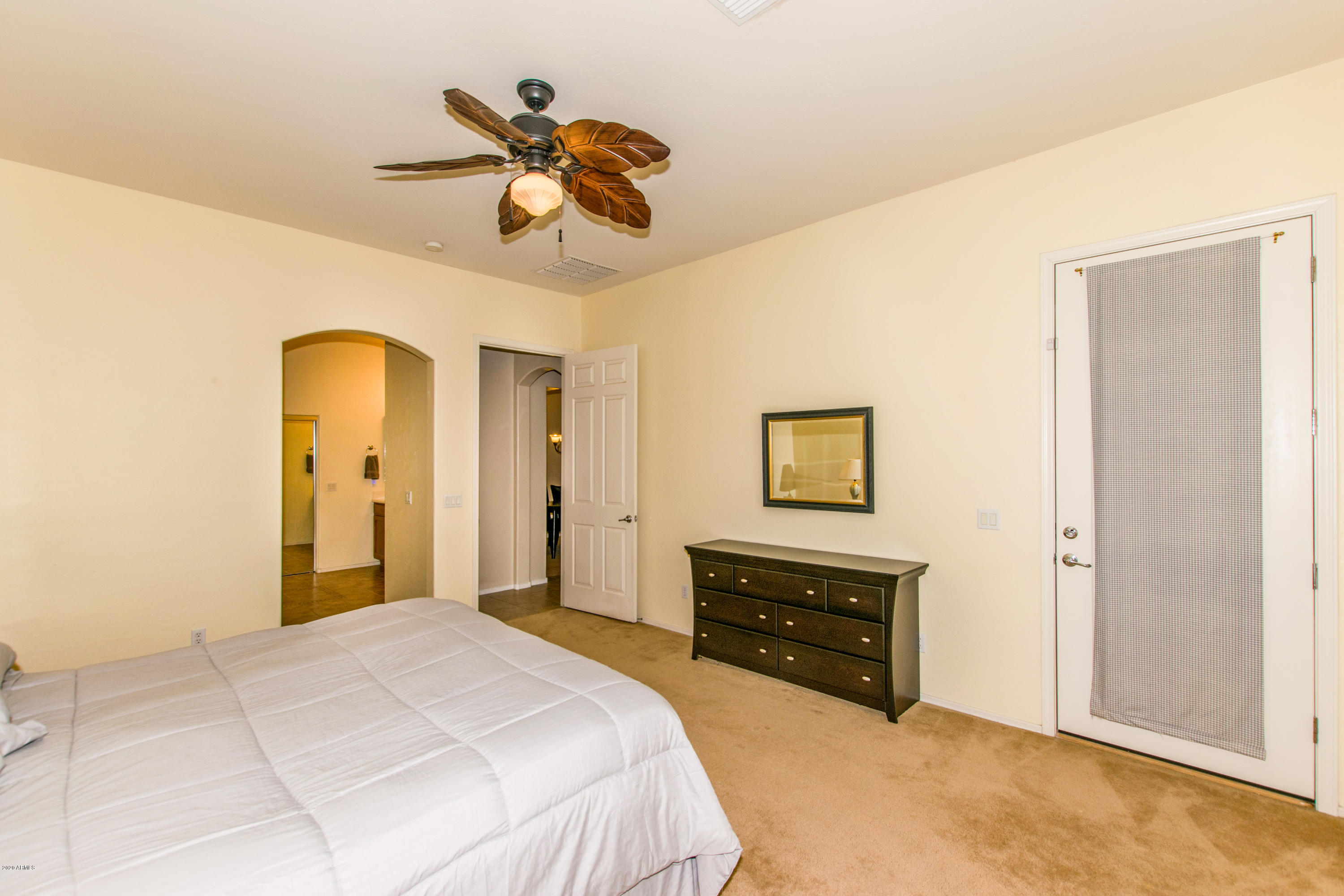 2426 West Apache Rain Road Phoenix, AZ 85085 - Photo 13 of 27 a bedroom with a bed and a chandelier
