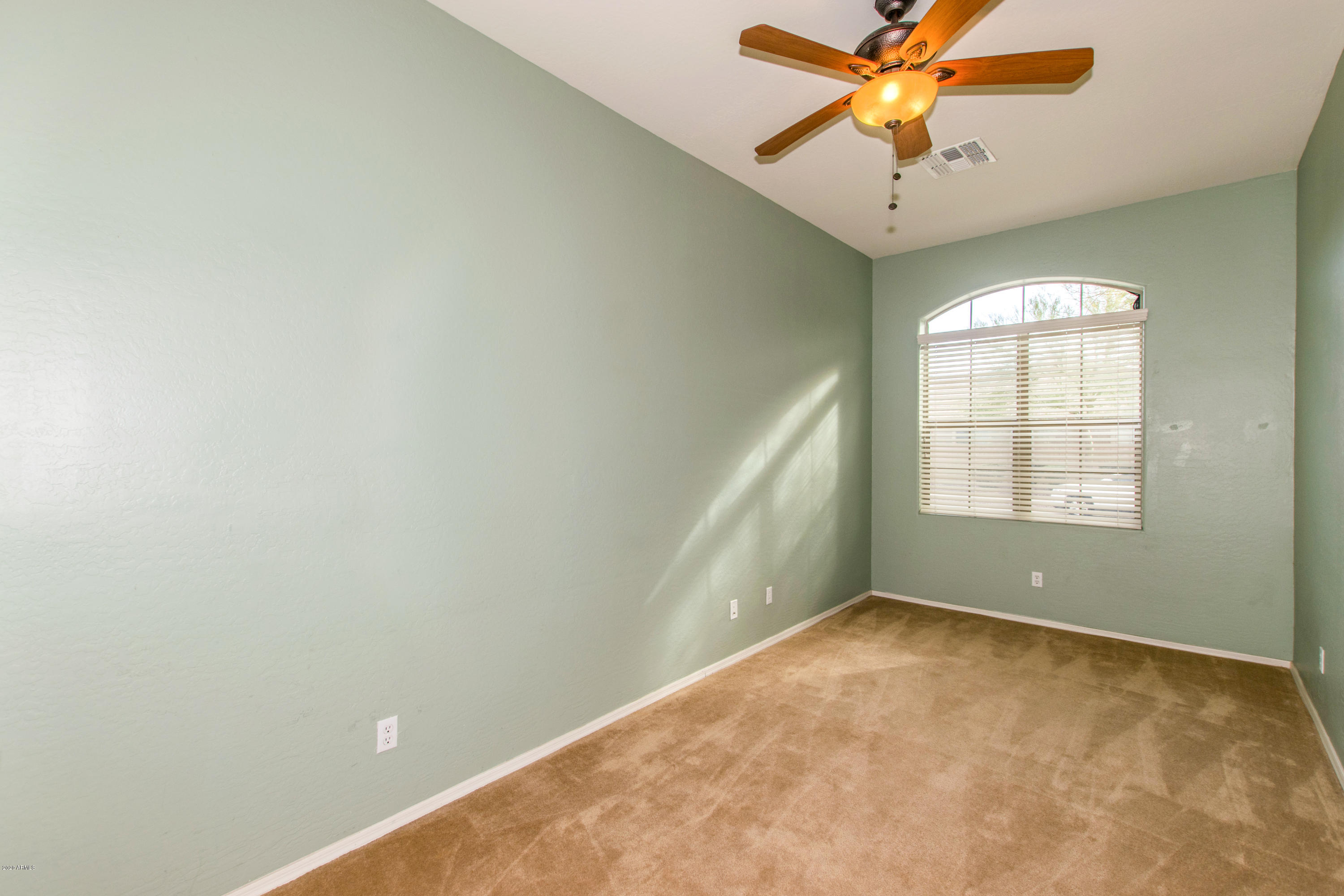 2426 West Apache Rain Road Phoenix, AZ 85085 - Photo 16 of 27 an empty room with a window and a fan