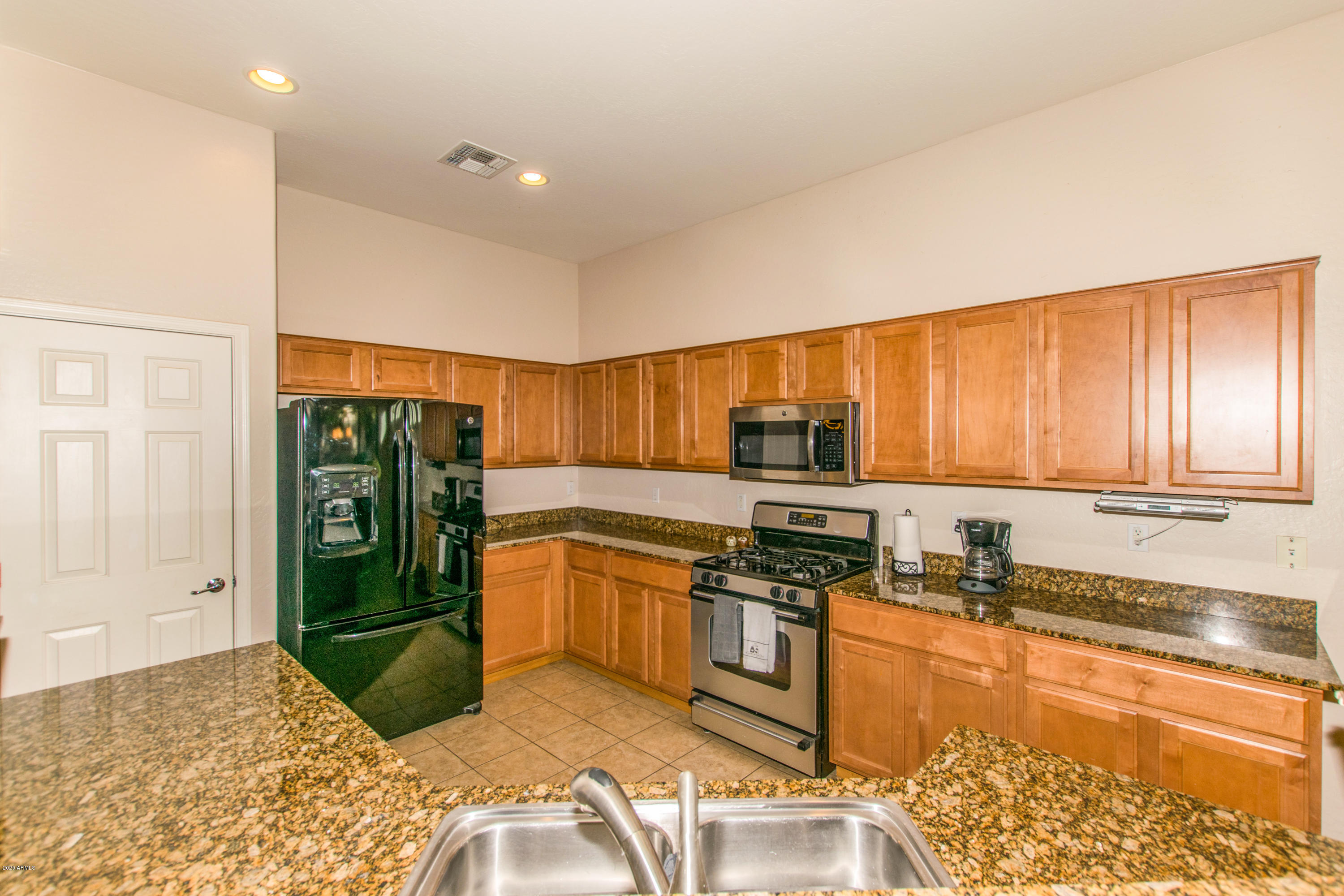 2426 West Apache Rain Road Phoenix, AZ 85085 - Photo 5 of 27 a kitchen with stainless steel appliances granite countertop a refrigerator and a stove top oven
