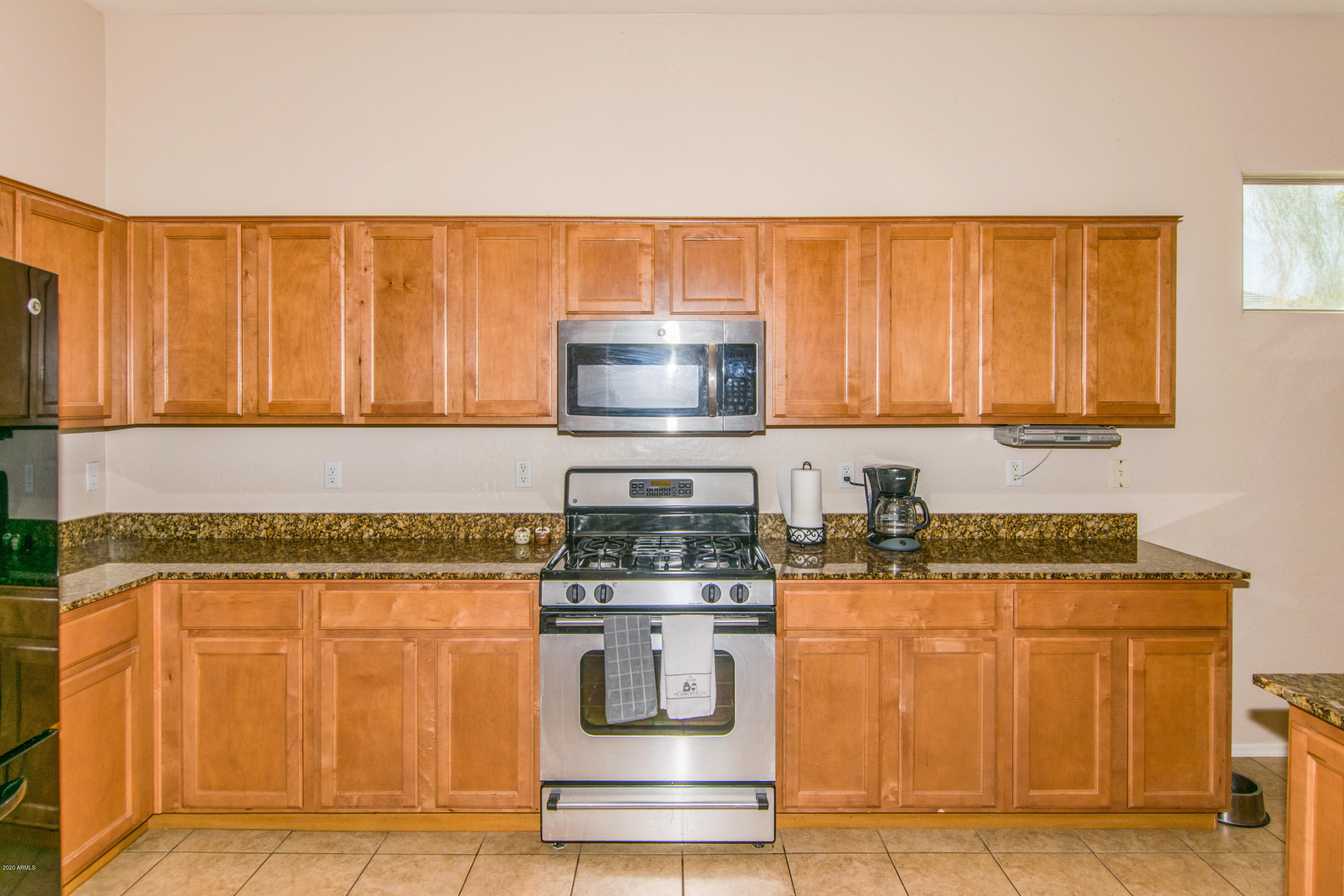 2426 West Apache Rain Road Phoenix, AZ 85085 - Photo 7 of 27 a kitchen with stainless steel appliances granite countertop a stove and a microwave oven