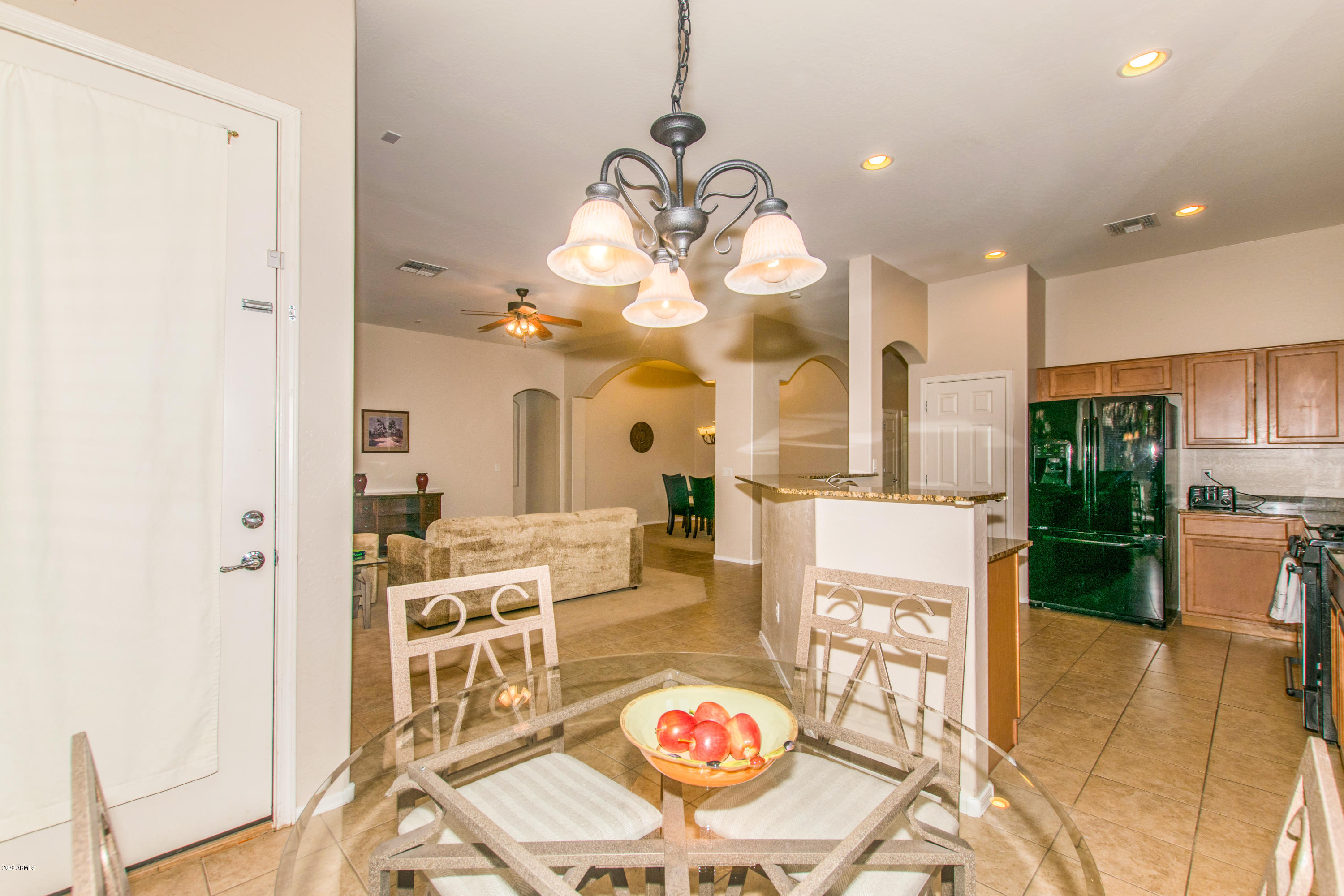 2426 West Apache Rain Road Phoenix, AZ 85085 - Photo 8 of 27 a view of a dining room with furniture a chandelier and wooden floor