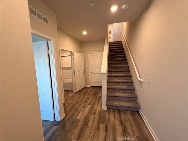 a view of a hallway with wooden floor and staircase