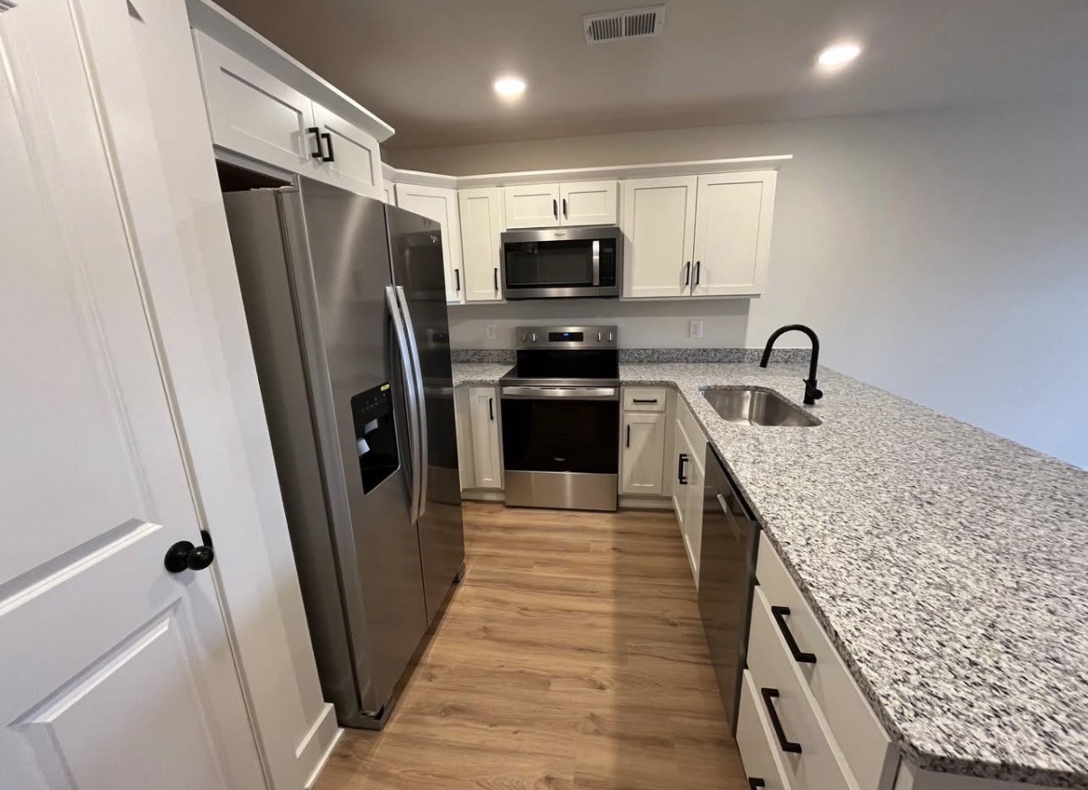 402 Portland Boulevard Portland, TN 37148 - Photo 12 of 16 a kitchen with stainless steel appliances granite countertop a refrigerator a sink a stove and cabinets