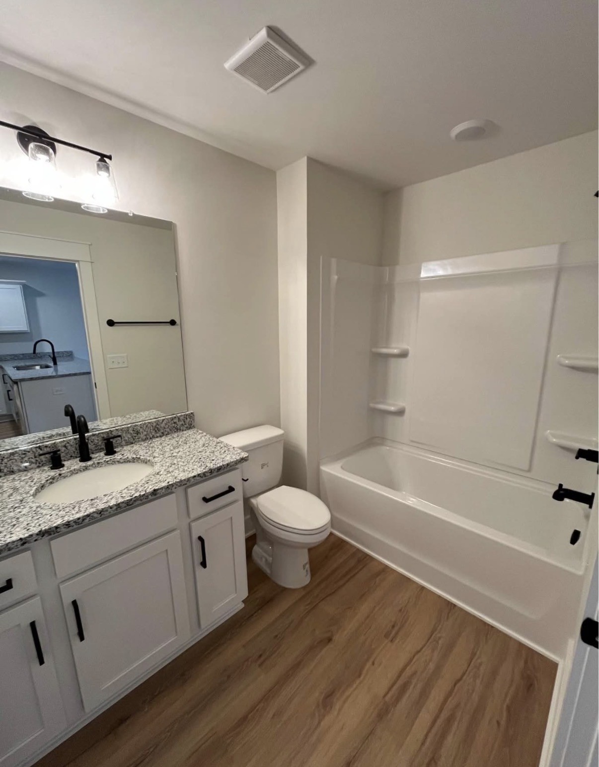 402 Portland Boulevard Portland, TN 37148 - Photo 6 of 16 a bathroom with a granite countertop sink toilet a large mirror a bathtub and shower