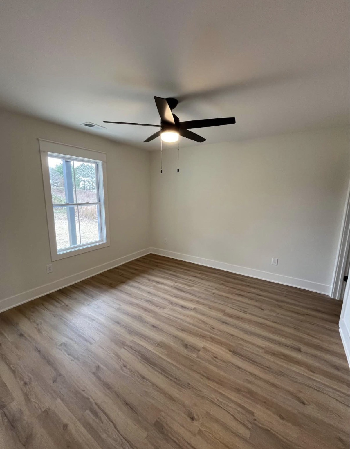402 Portland Boulevard Portland, TN 37148 - Photo 7 of 16 an empty room with wooden floor fan and windows