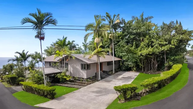 a front view of a house with a yard and potted plants