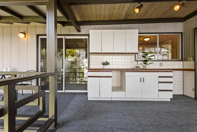 a kitchen with white cabinets and sink