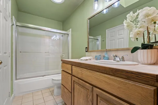 a bathroom with a granite countertop sink a toilet and shower