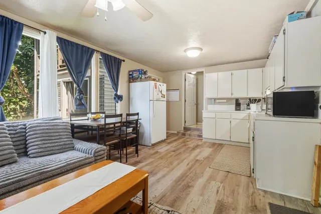 a kitchen with a table chairs refrigerator and window