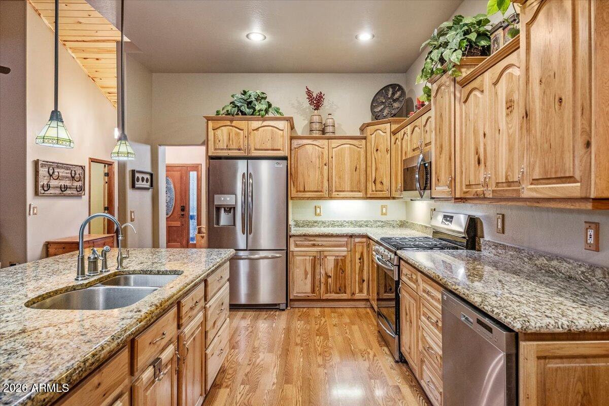 2952 Country View Lane Overgaard, AZ 85933 - Photo 22 of 81 a kitchen with stainless steel appliances granite countertop a sink a stove and a wooden cabinets
