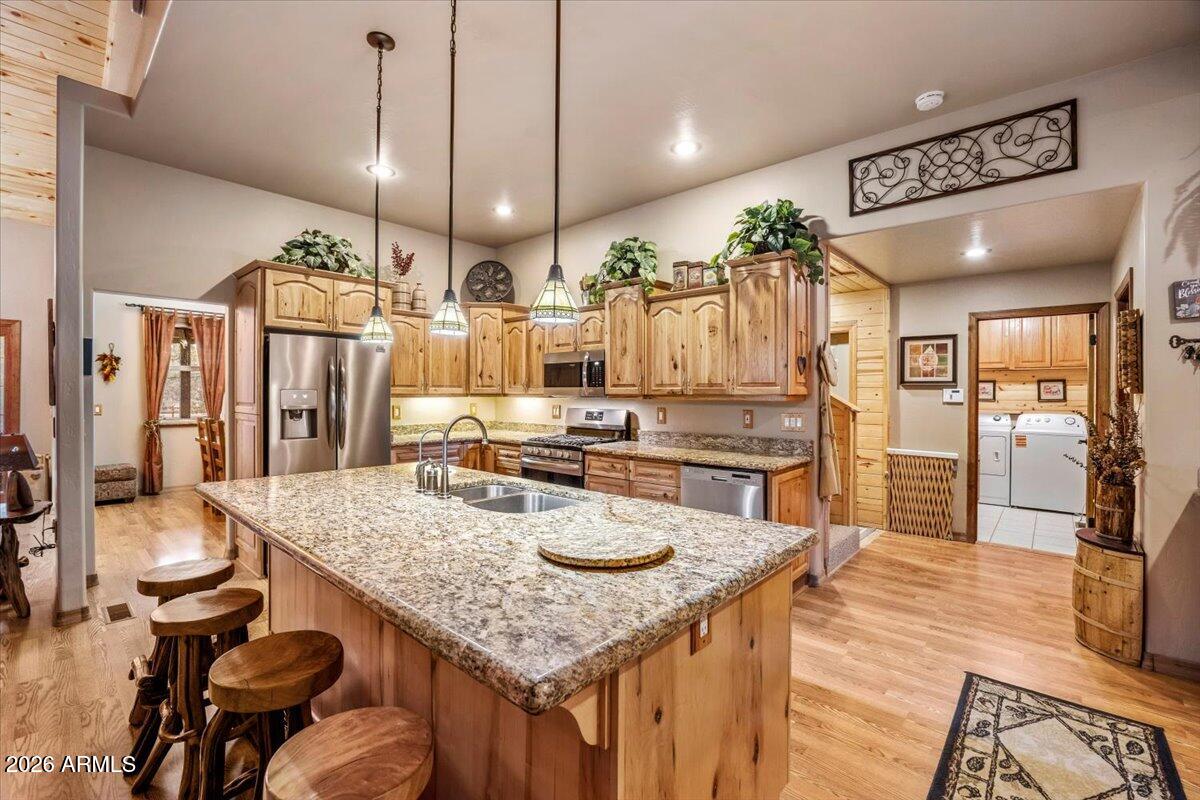 2952 Country View Lane Overgaard, AZ 85933 - Photo 23 of 81 a kitchen with stainless steel appliances granite countertop a stove a refrigerator a oven a sink with island chairs and wooden cabinets