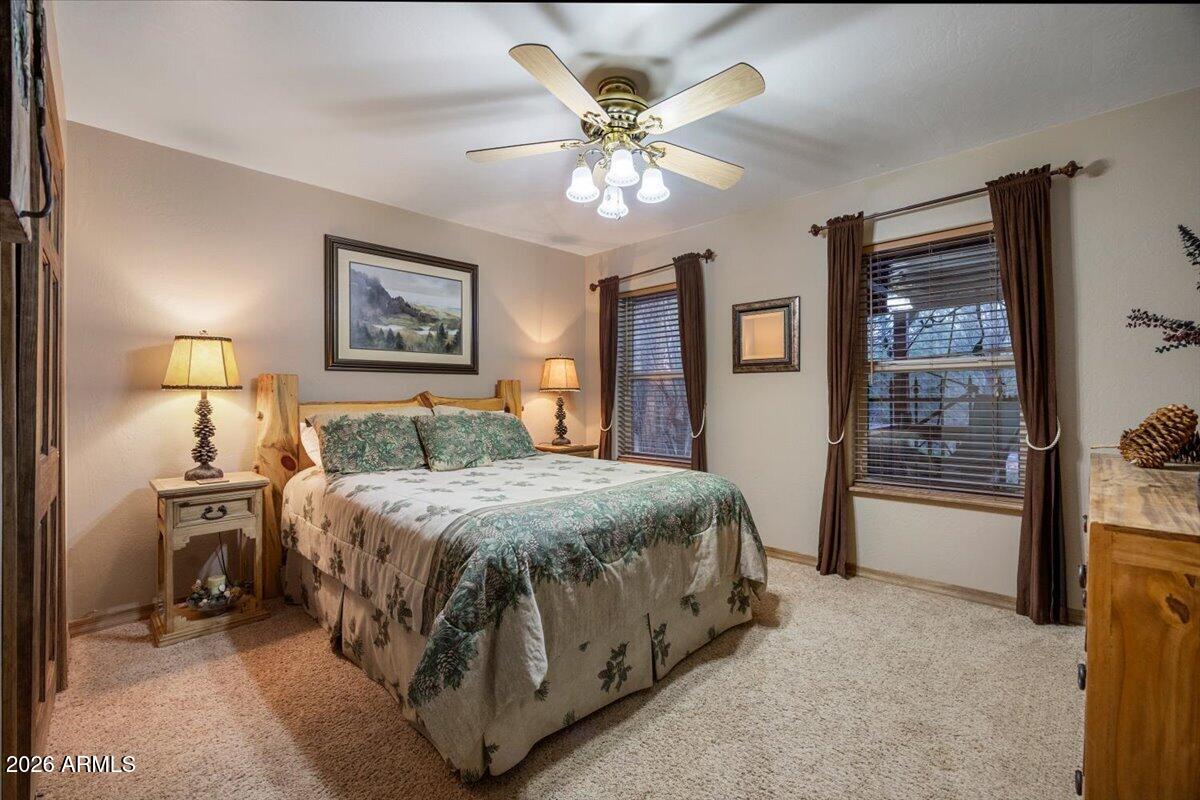 2952 Country View Lane Overgaard, AZ 85933 - Photo 30 of 81 a spacious bedroom with a bed and a chandelier