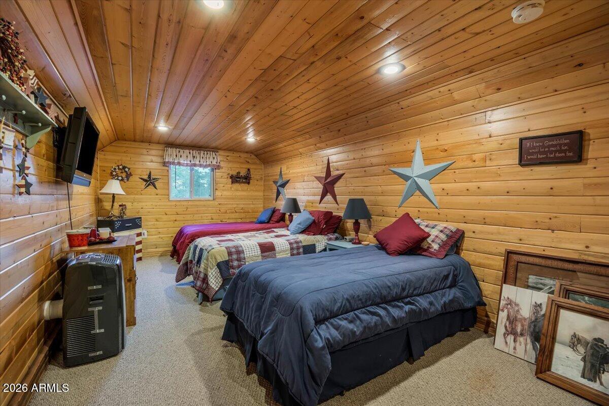 2952 Country View Lane Overgaard, AZ 85933 - Photo 34 of 81 a bedroom with bed and a chandelier