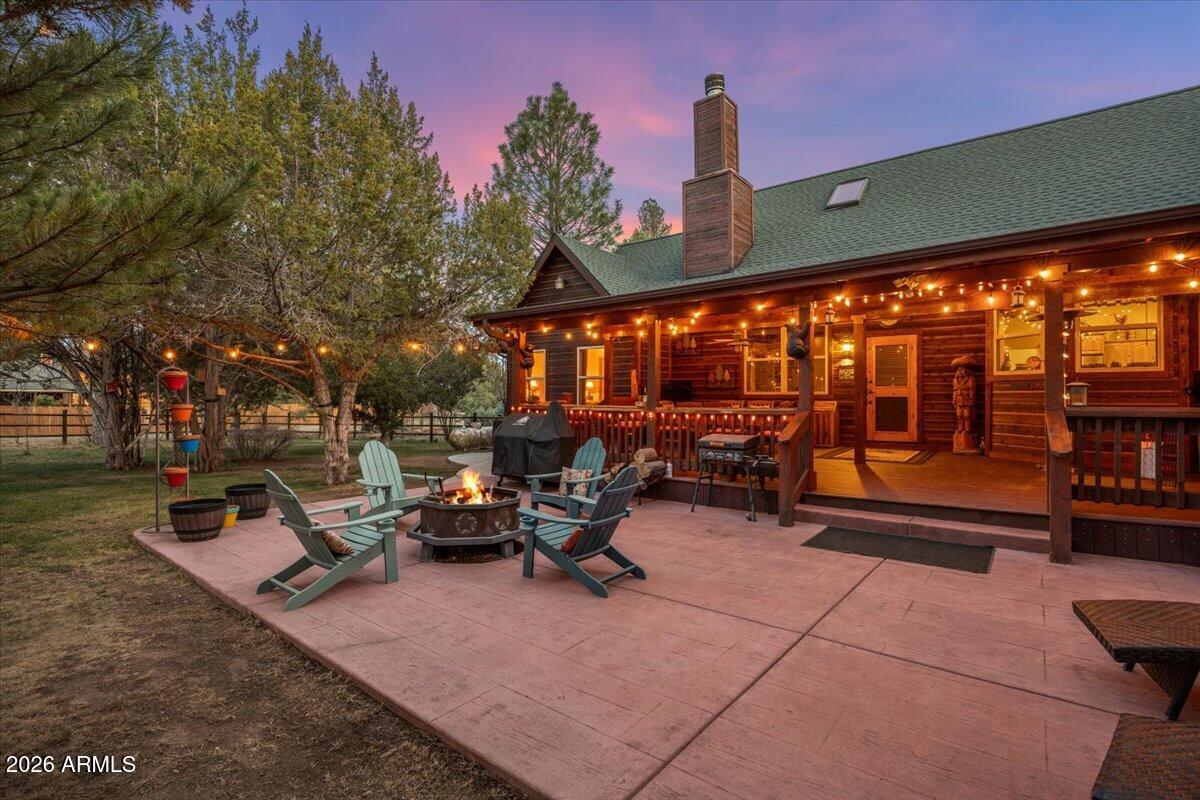 2952 Country View Lane Overgaard, AZ 85933 - Photo 48 of 81 a view of a patio with table and chairs under an umbrella with a fire pit
