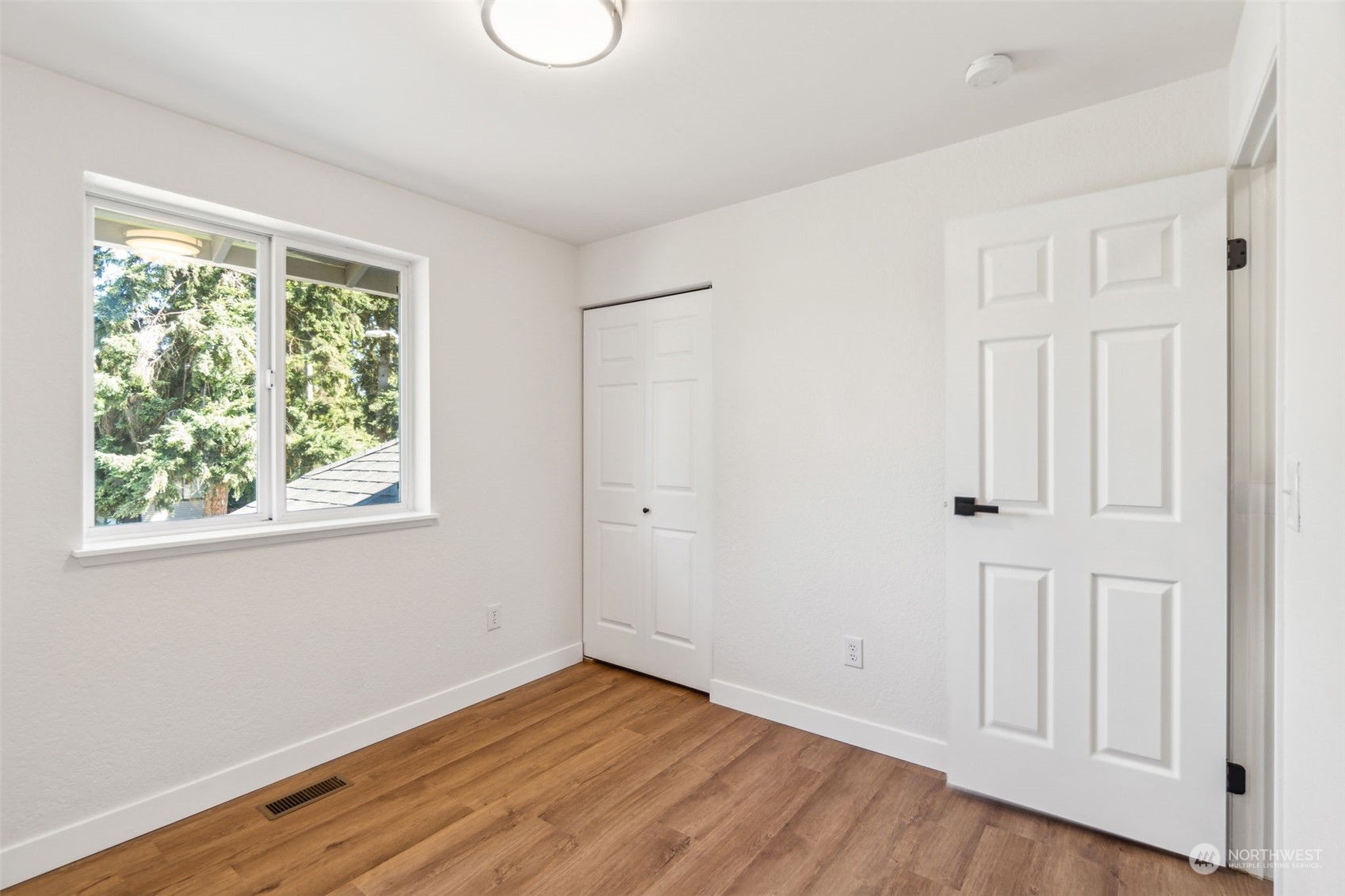 1901 Northeast 17th Place Renton, WA 98056 - Photo 24 of 40 a view of an empty room with wooden floor and a window