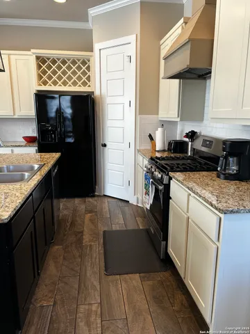 a kitchen with stainless steel appliances granite countertop a stove a sink and a refrigerator