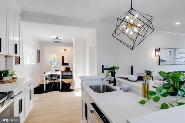 a kitchen with sink a microwave and cabinets