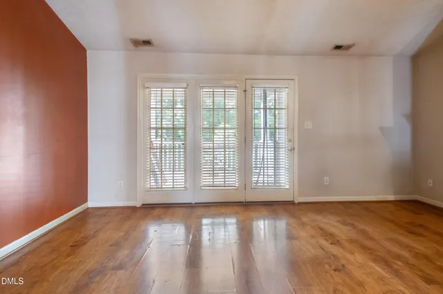 a view of empty room with wooden floor and fireplace