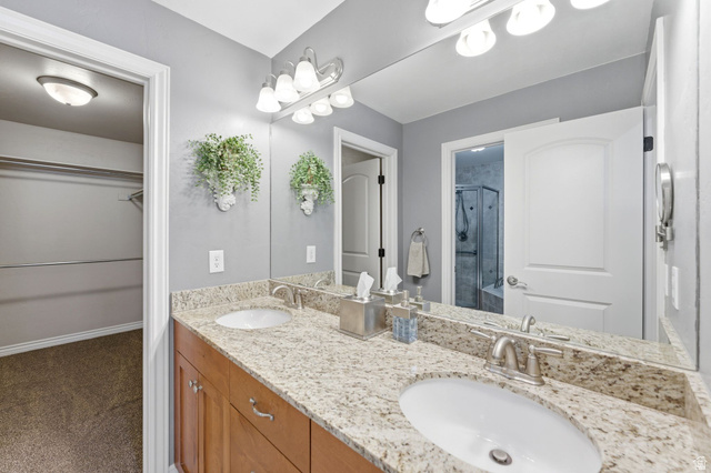 7235 Viansa Court Midvale, UT 84047 - Photo 18 of 43 Bathroom featuring double vanity, a stall shower, a walk in closet, and dark carpet
