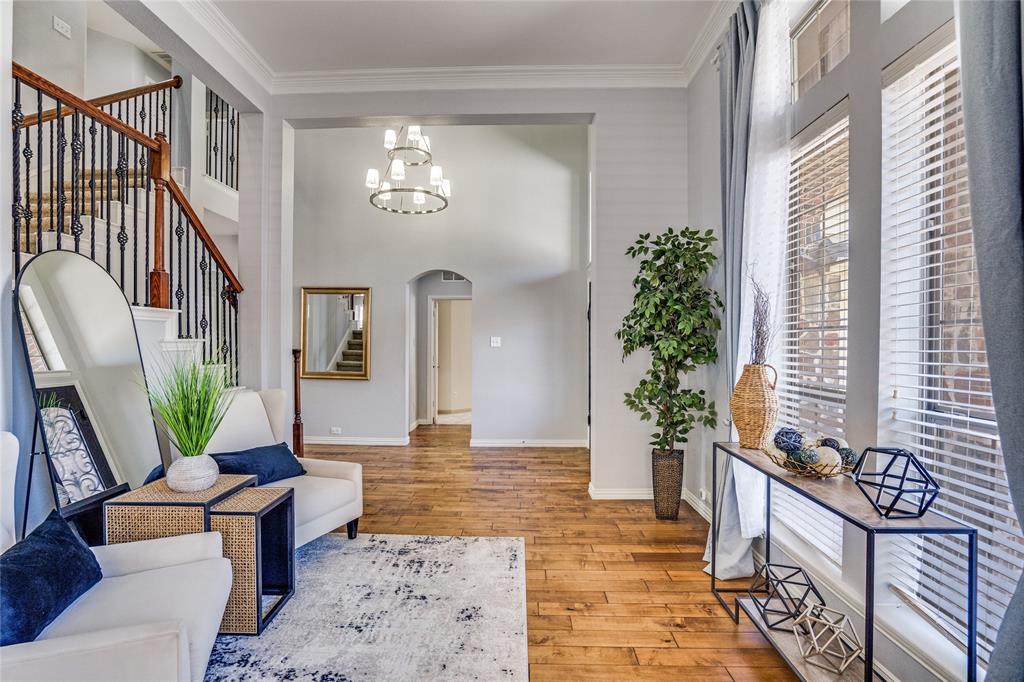 1804 Goodnight Lane Allen, TX 75002 - Photo 13 of 35 Foyer entrance featuring arched walkways, crown molding, suspended lighting, and solid hardwood flooring