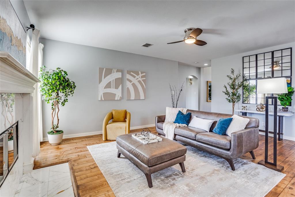 1804 Goodnight Lane Allen, TX 75002 - Photo 14 of 35 Living area with a ceiling fan, a fireplace, solid hardwood flooring, and arched walkways