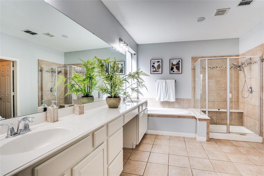 1804 Goodnight Lane Allen, TX 75002 - Photo 21 of 35 Full bathroom featuring a stall shower, double vanity, light tile patterned floors, and a garden tub