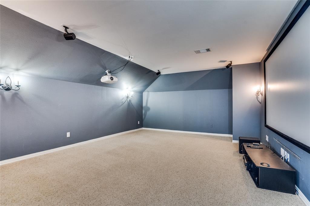 1804 Goodnight Lane Allen, TX 75002 - Photo 25 of 35 Home theater room with light carpet and lofted ceiling