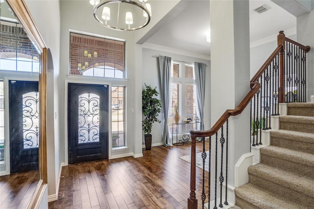 1804 Goodnight Lane Allen, TX 75002 - Photo 3 of 35 Foyer with suspended lighting, crown molding, and solid wood flooring
