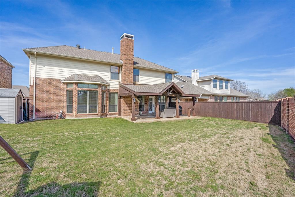 1804 Goodnight Lane Allen, TX 75002 - Photo 35 of 35 Back of house featuring a patio area, a chimney, a shed, brick siding, and a fenced backyard