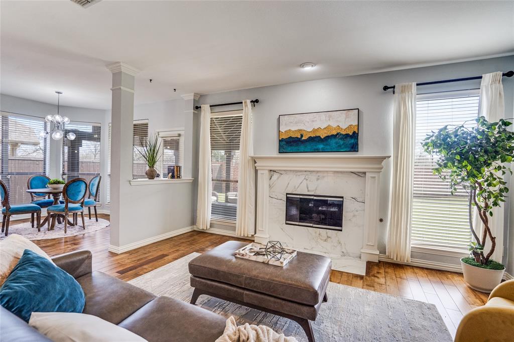 1804 Goodnight Lane Allen, TX 75002 - Photo 5 of 35 Living room featuring solid wood flooring, hanging lights, and a high end fireplace