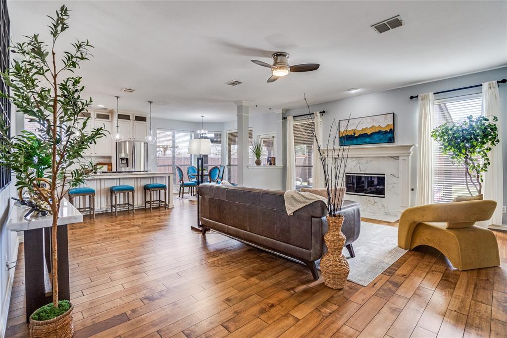 1804 Goodnight Lane Allen, TX 75002 - Photo 8 of 35 Living area featuring solid hardwood flooring, a high end fireplace, ceiling fan, and a chandelier