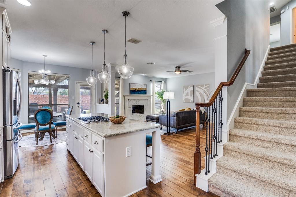 1804 Goodnight Lane Allen, TX 75002 - Photo 10 of 35 Kitchen with white cabinetry, a breakfast bar, a center island, and light stone counters