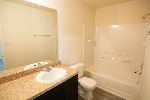 a bathroom with a granite countertop sink toilet and shower