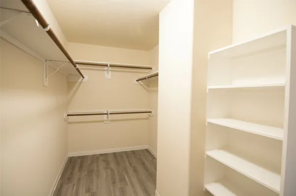 a view of walk in closet with empty racks