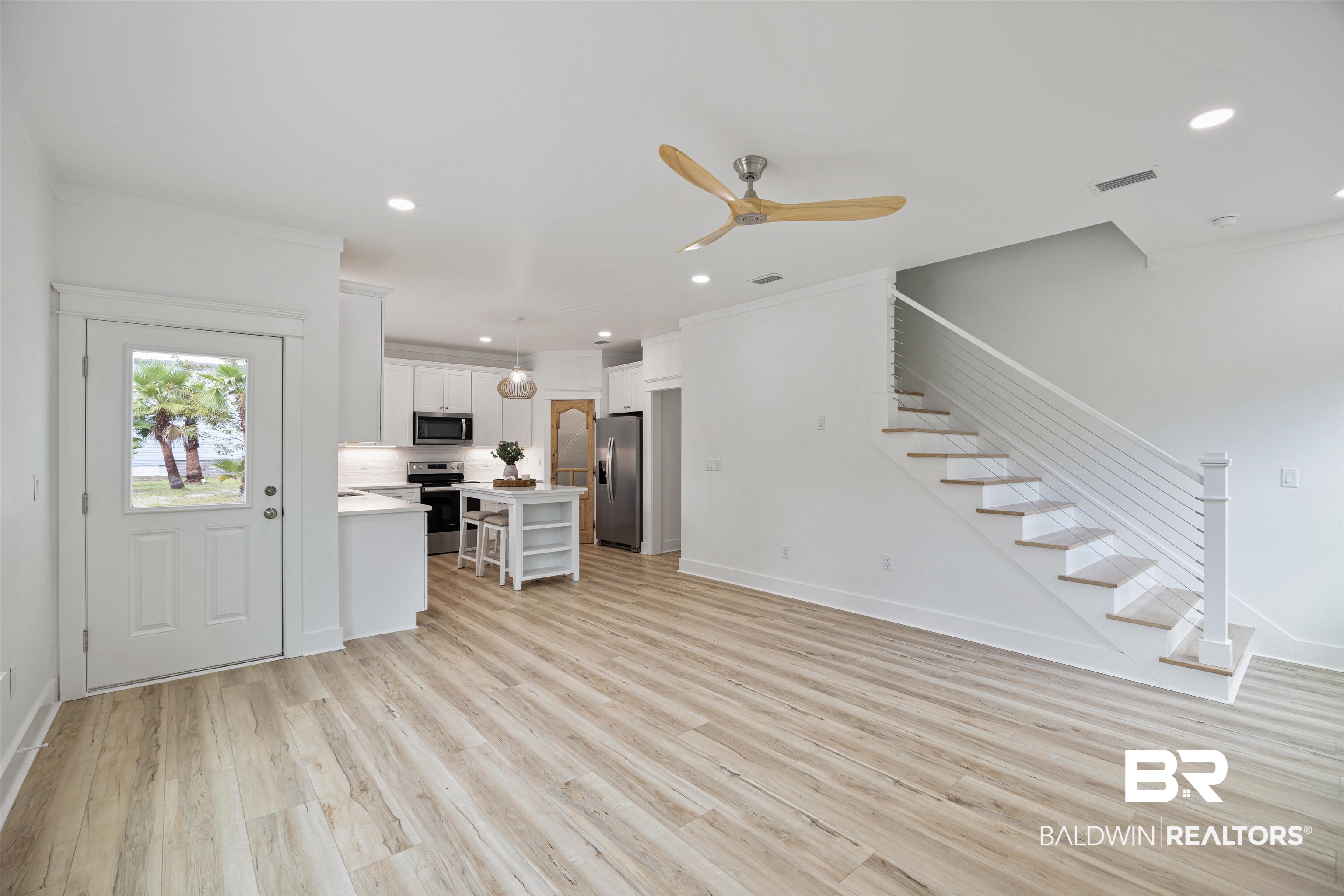 27591 Canal Road Orange Beach, AL 36561 - Photo 8 of 51 Unfurnished living room with stairs, light wood-style floors, ceiling fan, recessed lighting, and crown molding