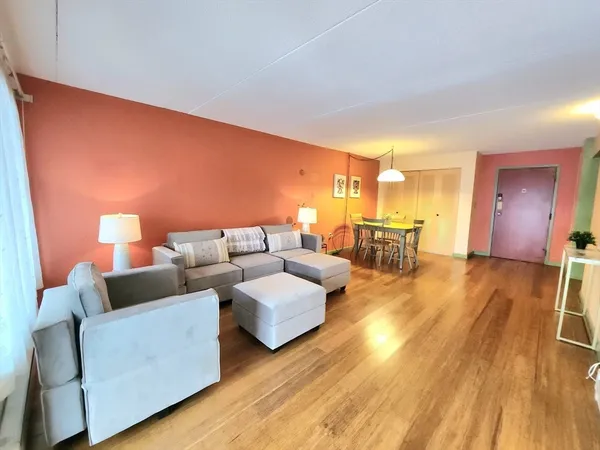 a living room with furniture and a wooden floor