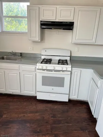 a white stove top oven sitting inside of a kitchen