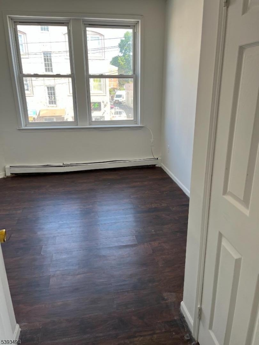 340 Morris Avenue Elizabeth, NJ 07208 - Photo 8 of 8 an empty room with wooden floor and windows