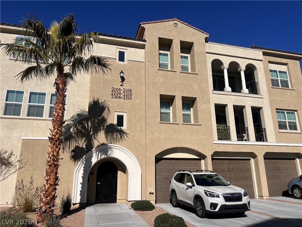 2555 Hampton Road, Unit 2207 Henderson, NV 89052 - Photo 1 of 74 Mediterranean-inspired multi-story residence with integrated garages and prominent palm tree.